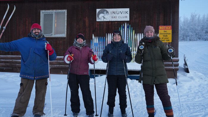 Quatre skieurs à l'extérieur, habillés pour résister au grand froid.