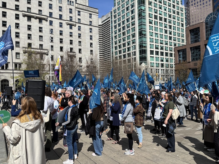 Un rassemblement de personnes à l'extérieur avec des drapeaux.