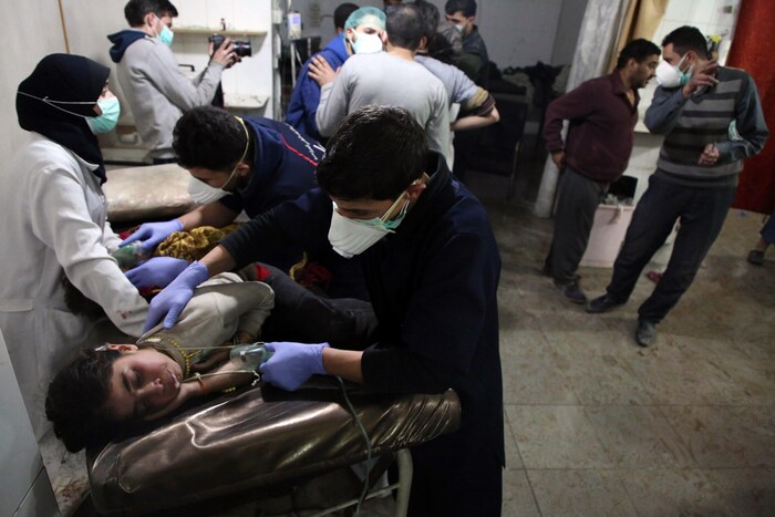 Du personnel médical utilise des masques à oxygène pour venir en aide à des enfants étendus sur des civières.