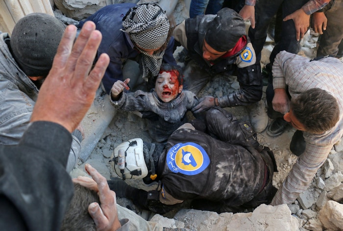 Des Casques blancs sortent un enfant des décombres d'un bâtiment détruit par une explosion, à Neirab, en Syrie, le 24 novembre 2016.
