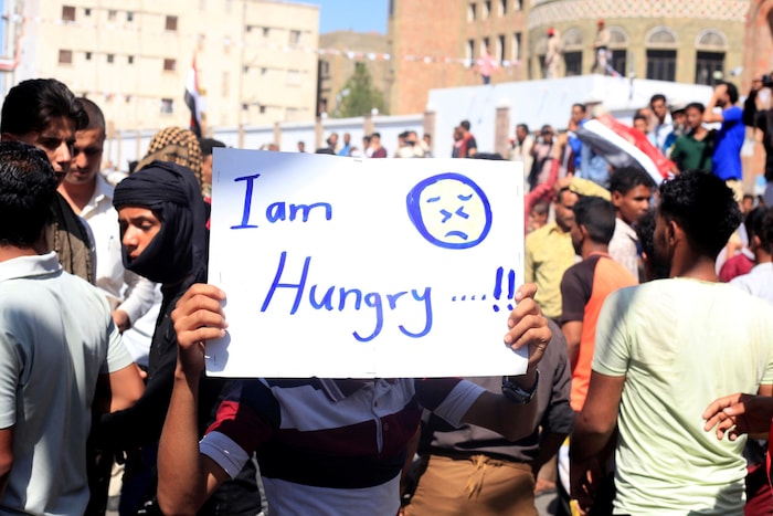 Un manifestant tient une affiche sur laquelle est écrit : « I am hungry ».