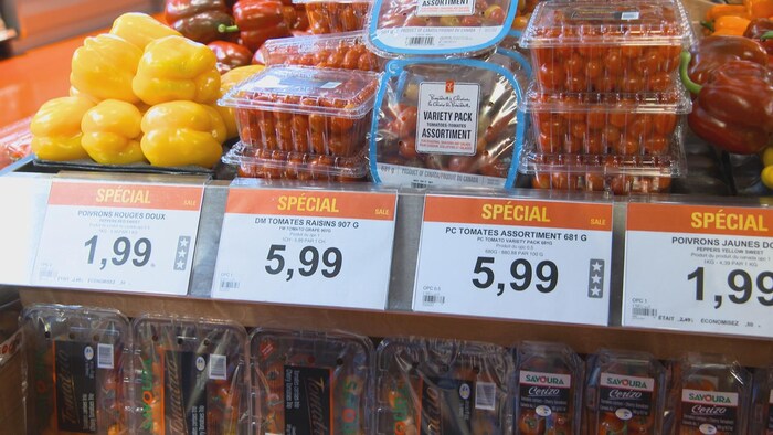 Des barquettes contenant des tomates cerises au supermarché. Différents prix sont indiqués