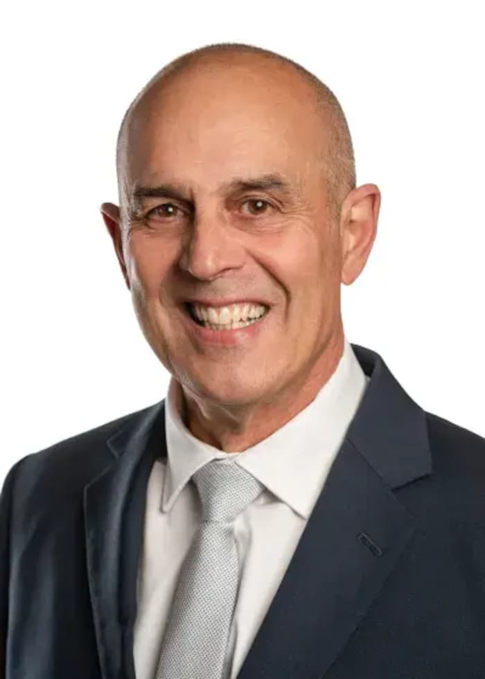Portrait de Tony Baldinelli chauve, qui sourit à la caméra.
