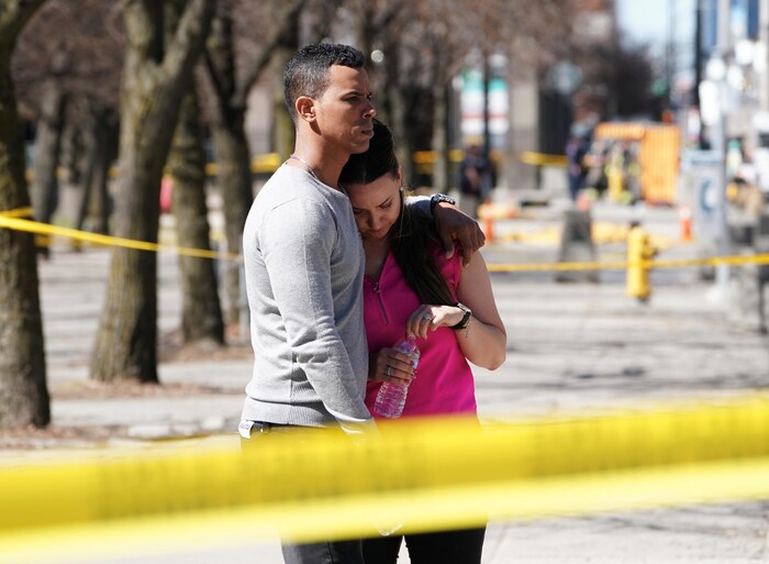 Deux personnes tentent de se réconforter après les événements qui se sont produits lundi sur la rue Yonge, à Toronto. Le chauffeur d'un véhicule aurait frappé plusieurs piétons dans la rue et sur les trottoirs. 