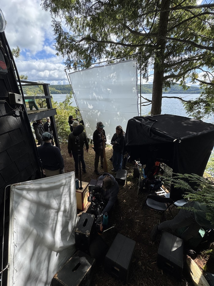 Une équipe de tournage sur le bord d'un lac.