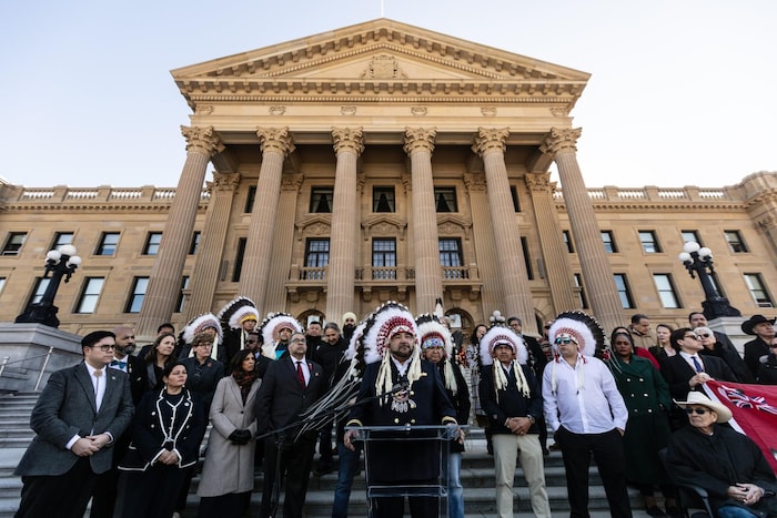 Un groupe de personnes est réunie devant uine Assemblée législative.