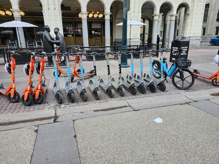 Des trottinettes électriques sont disposées dans une rue du centre-ville de Calgary, le 19 mai 2024.