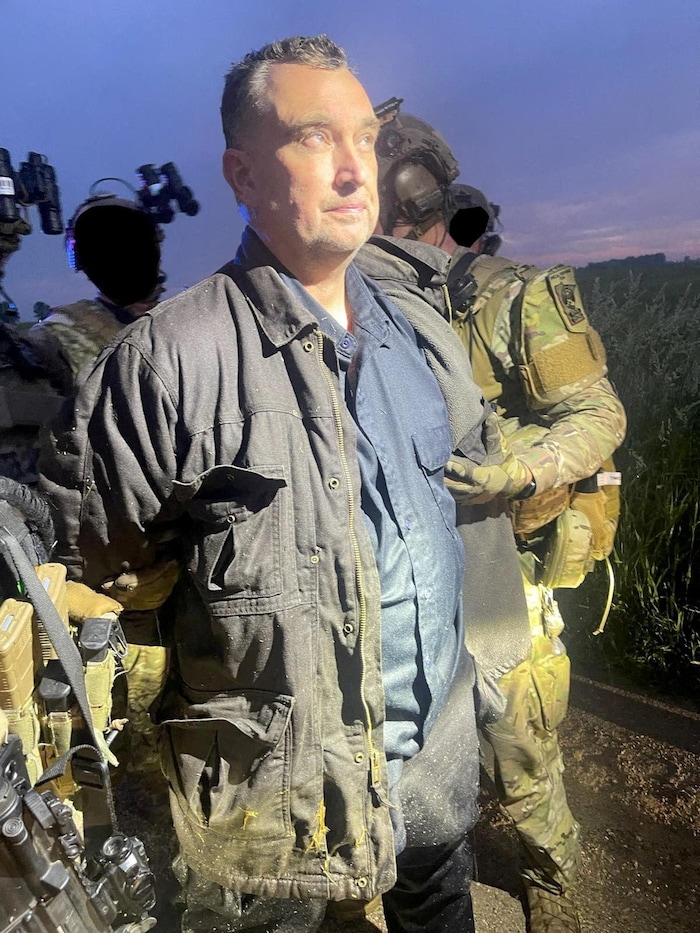 Vance Luther Boelter, entouré de policiers lourdement armés, est menotté.