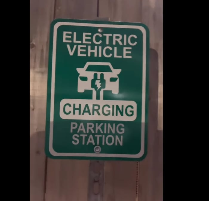 Une pancarte indique une station de recharge de véhicules électriques.