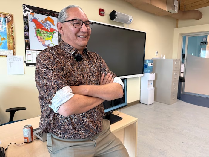 Vern Lewis est debout dans une salle de classe. 