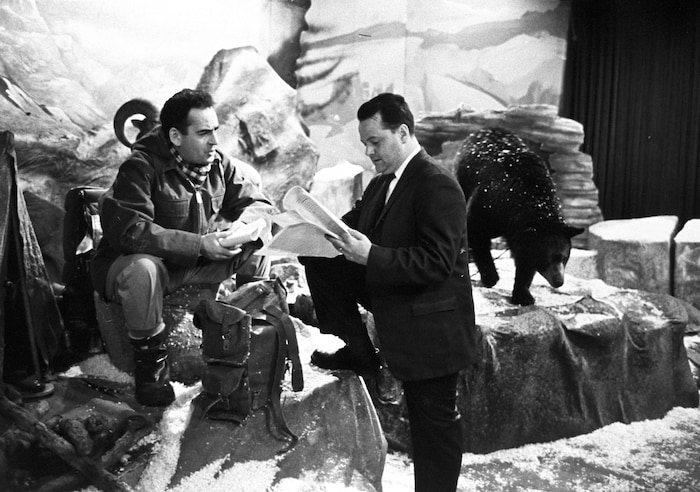 L'animateur Guy Provost discute avec le réalisateur Michel Demers qui consulte son
plan de l'émission, sans se préoccuper de l'ourson qui se promène derrière lui.