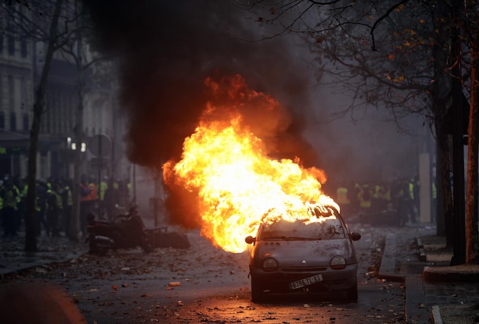 Une voiture en feu dans une rue de Paris après le passage de manifestants.