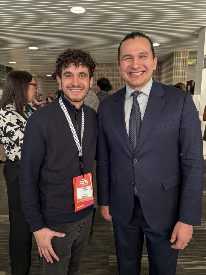 Un jeune à côté de Wab Kinew.