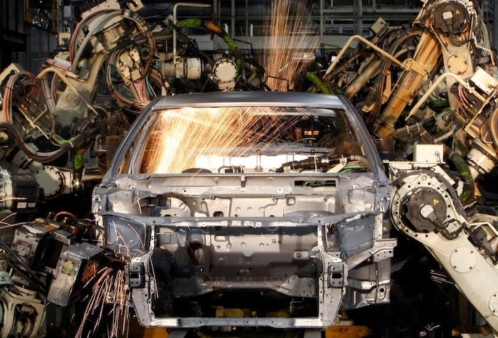 Robots welding the bodyshell of a car at a plant.