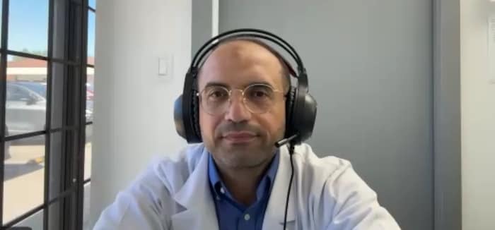 Une personne portant un casque audionumérique sur les oreilles fixe du regard l'objectif d'une caméra.