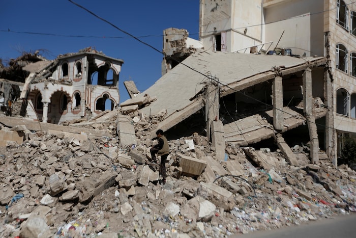 Un garçon marche sur les ruines d'un bâtiment, à Sanaa.