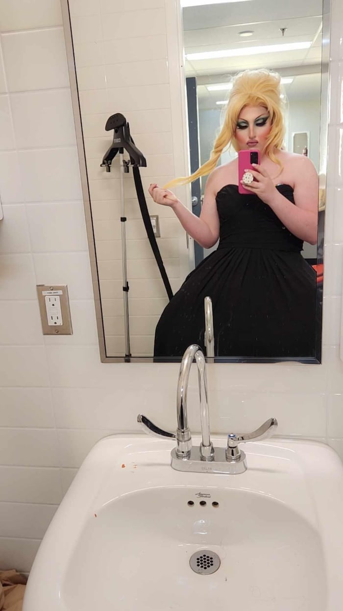 Un jeune homme se photographie en drag devant le miroir.