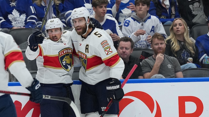 Deux joueurs célèbrent un but devant des partisans torontois déçus.