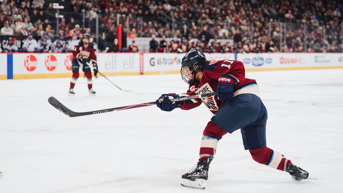 Une joueuse de hockey décoche un tir.