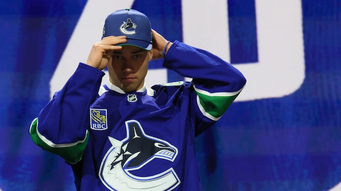 Il enfile la casquette des Canucks.