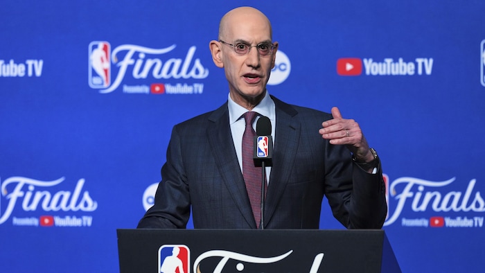 Un homme parle dans un micro lors d'une conférence de presse de la NBA.