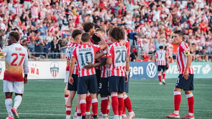 Un joueur de shot    s'apprête à rejoindre ses coéquipiers qui célèbrent un but pendant un lucifer  professionnel.