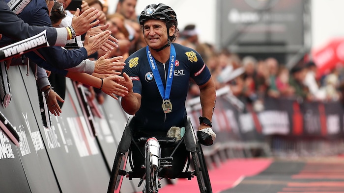 Alessandro Zanardi, souriant, serre des mains à l'arrivée d'une course en 2019.