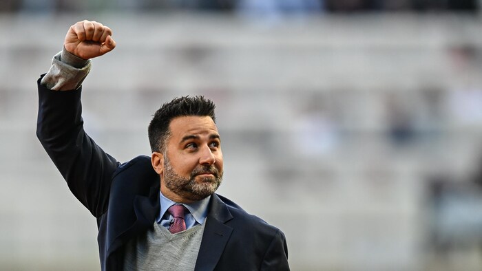 Alex Anthopoulos, dans un complet, lève le poing pour saluer la foule à Atlanta après une cérémonie en honneur de leur titre de Série mondiale.