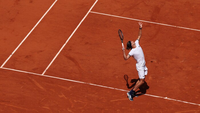 Un joueur de tennis effectue son service.