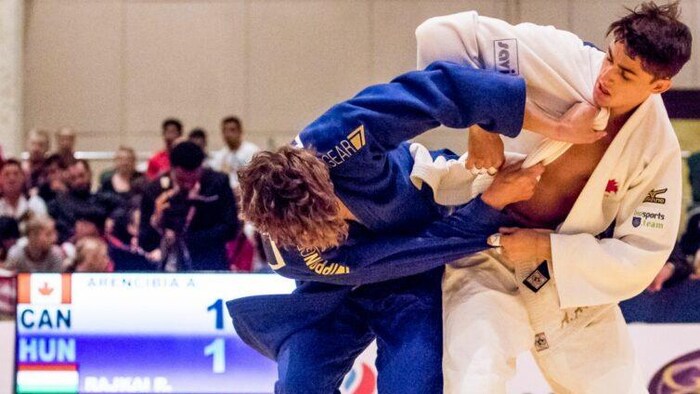 Deux judokas se battent sur un tatami pendant une compétition.
