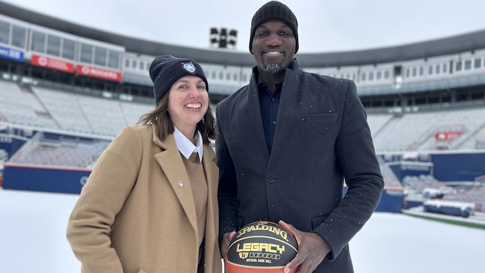 Une femme et un homme avec sur un terrain de tennis enneigé