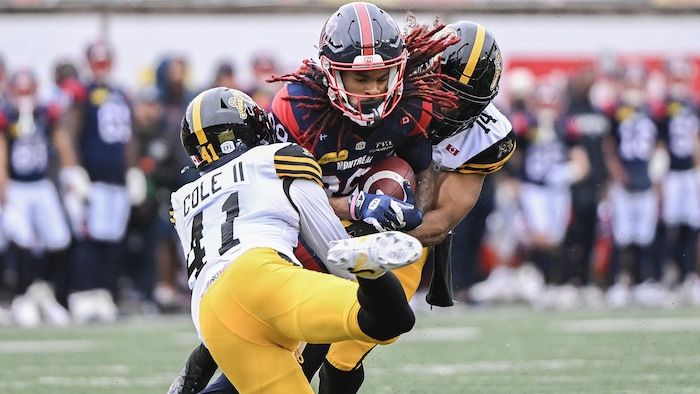 James Letcher fils, des Alouettes, se fait plaquer par Brian Cole et Maalik Hall des Tiger-Cats de Hamilton.
