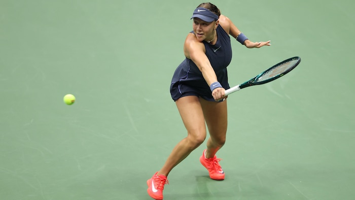 Une joueuse de tennis s'apprête à frapper un revers.