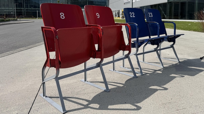 On voit d'anciens bancs d'aréna devant un nouveau centre de hockey.