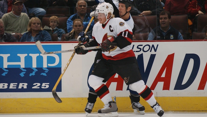Deux joueurs de hockey professionnels s'accrochent pendant un match.