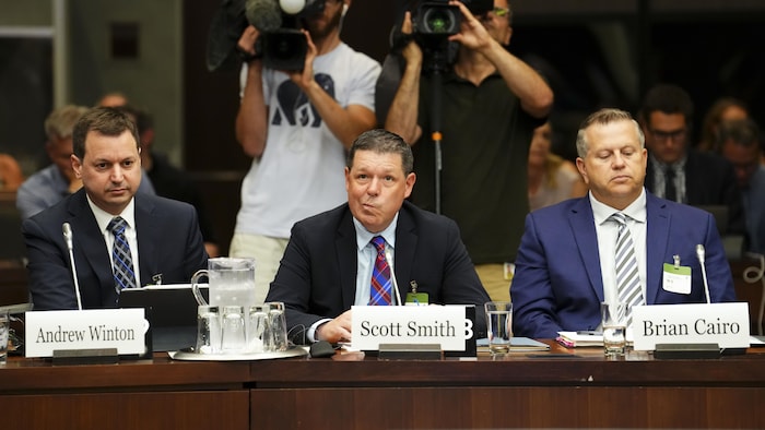 Tres hombres ante una comisión en Ottawa.