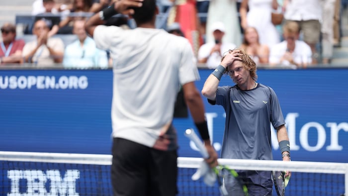 Deux joueurs de tennis s'approchent du filet après le match. 