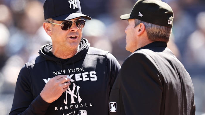Deux hommes discutent sur un terrain de baseball.