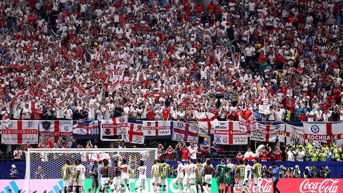 Une marée de supporteurs anglais remplissent les gradins et sont applaudis par les joueurs.