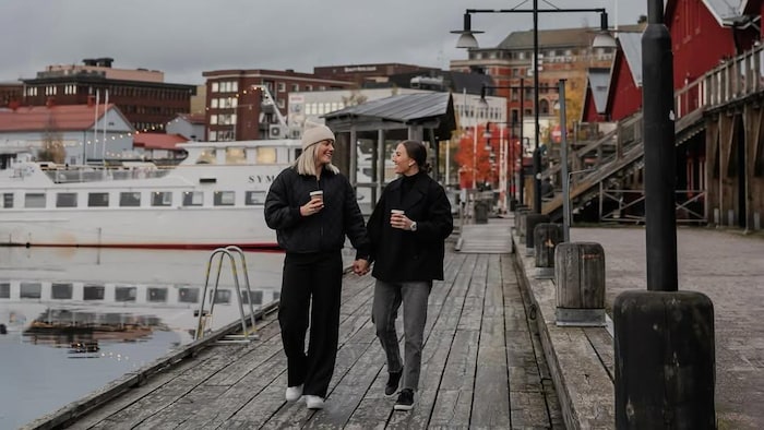 Deux femmes marchent main dans la main. 
