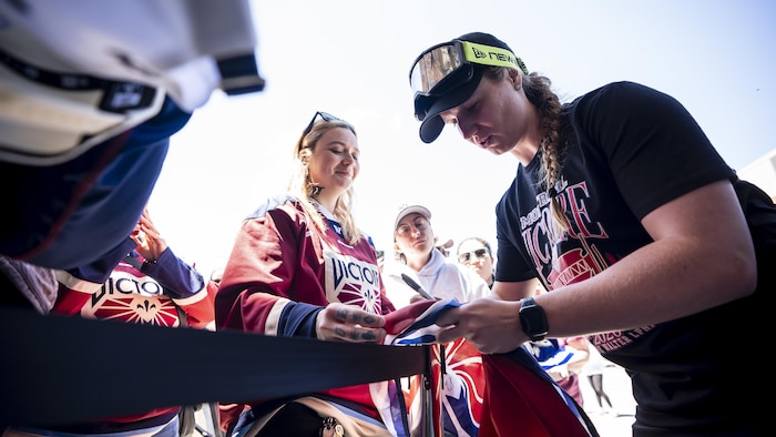 Elle signe un autographe.