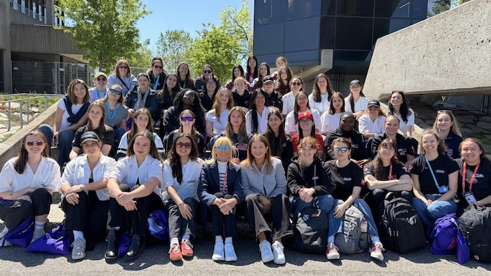 Un groupe d'étudiantes en génie posent pour la phot sur des marches.