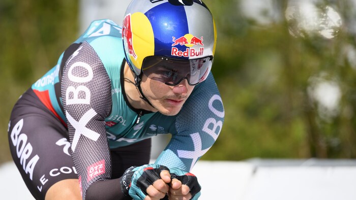 Le cycliste est en position aérodynamique sur son vélo.