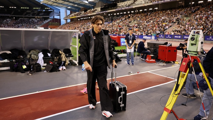 Il prend ses valises, l'air déçu, et quitte le stade.