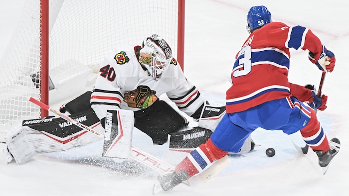 Un hockeyeur déjoue un gardien.