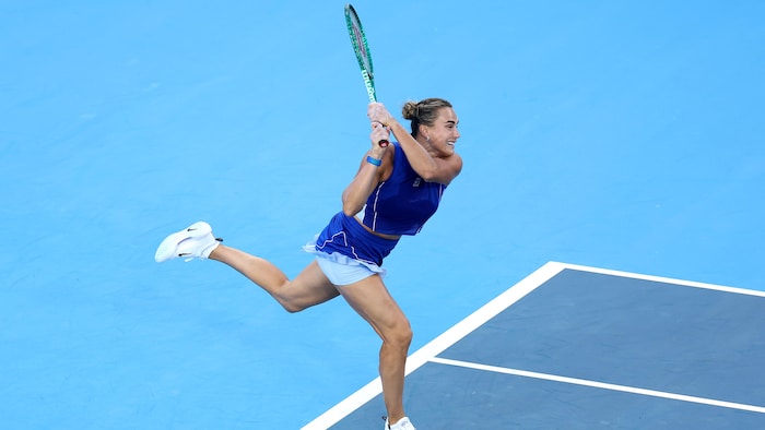 Une joueuse de tennis termine son élan.