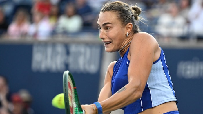 Une joueuse de tennis frappe un revers.