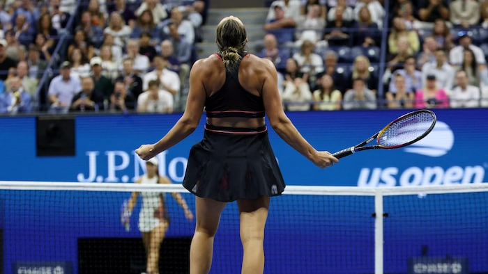 Elle crie de joie alors que son adversaire marche vers le filet.