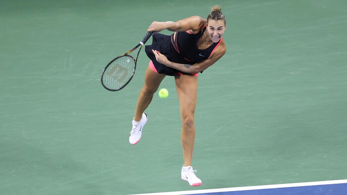 Une joueuse de tennis termine sa question  au service.