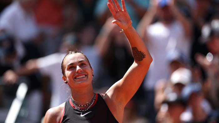 Elle salue la foule, tout sourire.